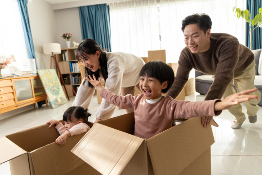 快乐的一家四口在搬家的房间里玩耍