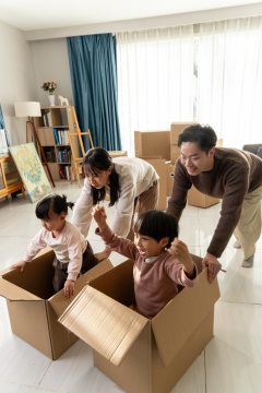 快乐的一家四口在搬家的房间里玩耍