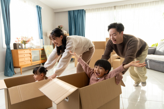 快乐的一家四口在搬家的房间里玩耍