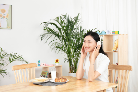 带着耳麦喝牛奶的年轻女性