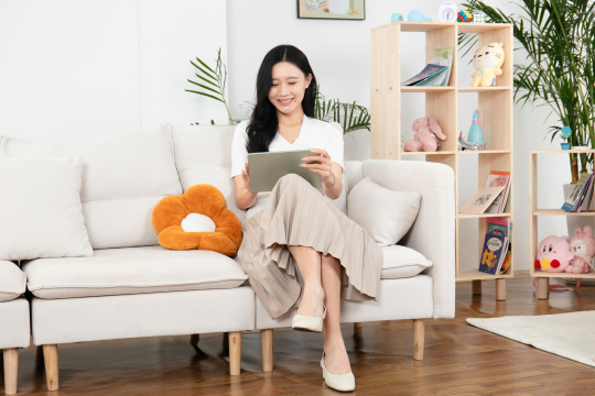 专注看平板电脑的年轻妈妈