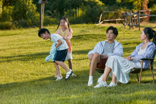 围绕着父母奔跑追逐的两个小朋友