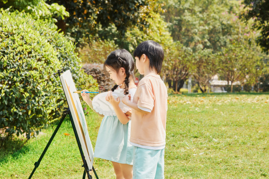 在草坪上画画的兄妹