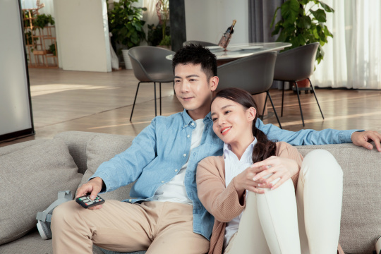 坐在客厅看电视的青年男女