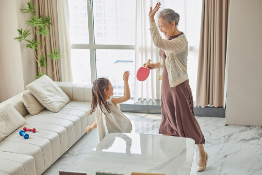 老人和孙女在家打乒乓球