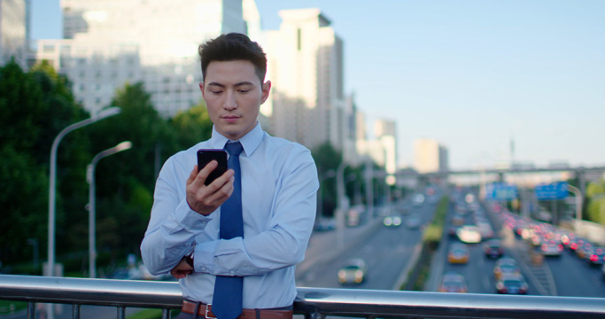 年轻商务男士在户外使用手机