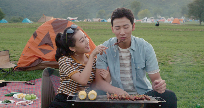 快乐的年轻情侣在户外烧烤