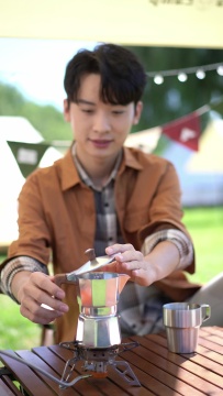 男孩坐天幕下煮咖啡